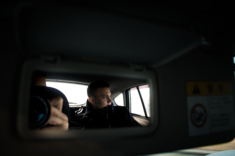 A Man In Black Jacket Inside The Car