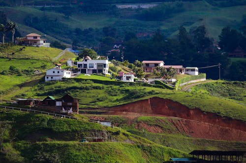 An Aerial Photography of Houses on Green Grass Field