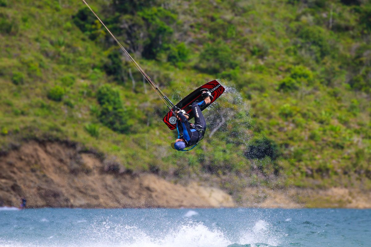Wakeboarder catching air over a sunny lake