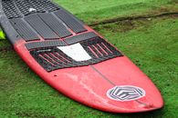 A Red and Black Wakesurf Board with a Traction Pad