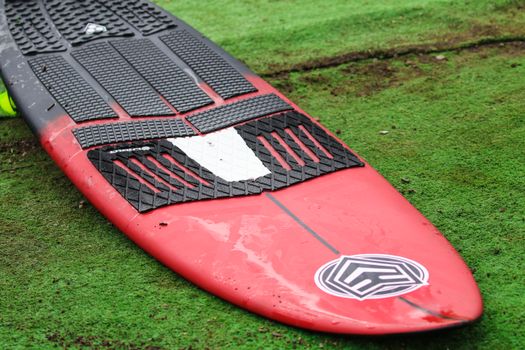 A Red and Black Wakesurf Board with a Traction Pad