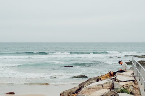 Man Sitting On Rocks