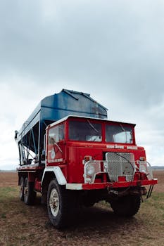 一辆用于丛林消防队的老式红色卡车，停在多云天空下的澳大利亚乡村景观中