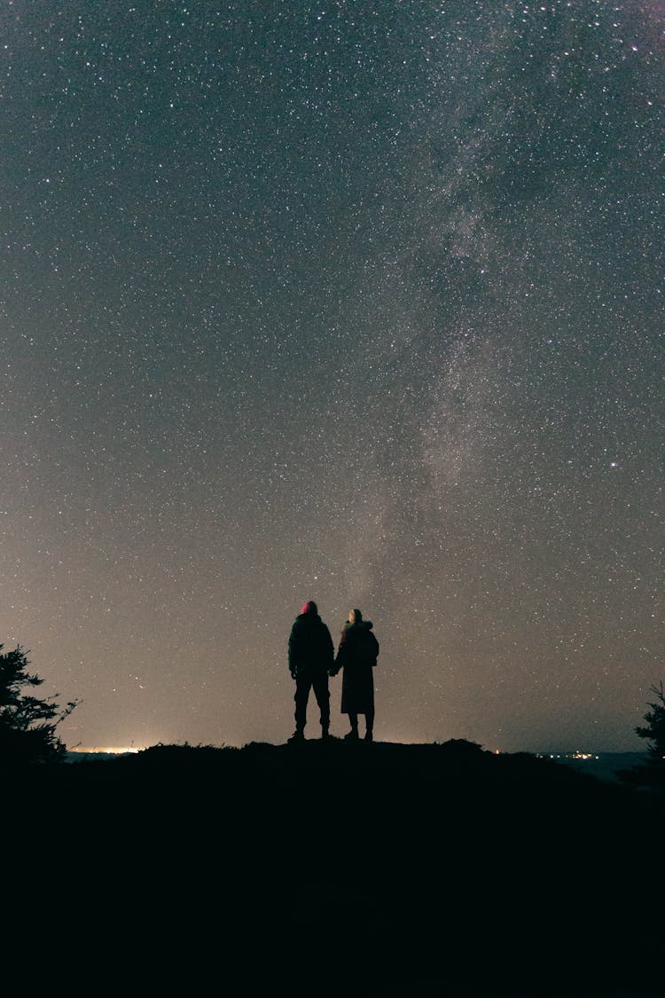 Silhouette Of Couple Under Stars At Night