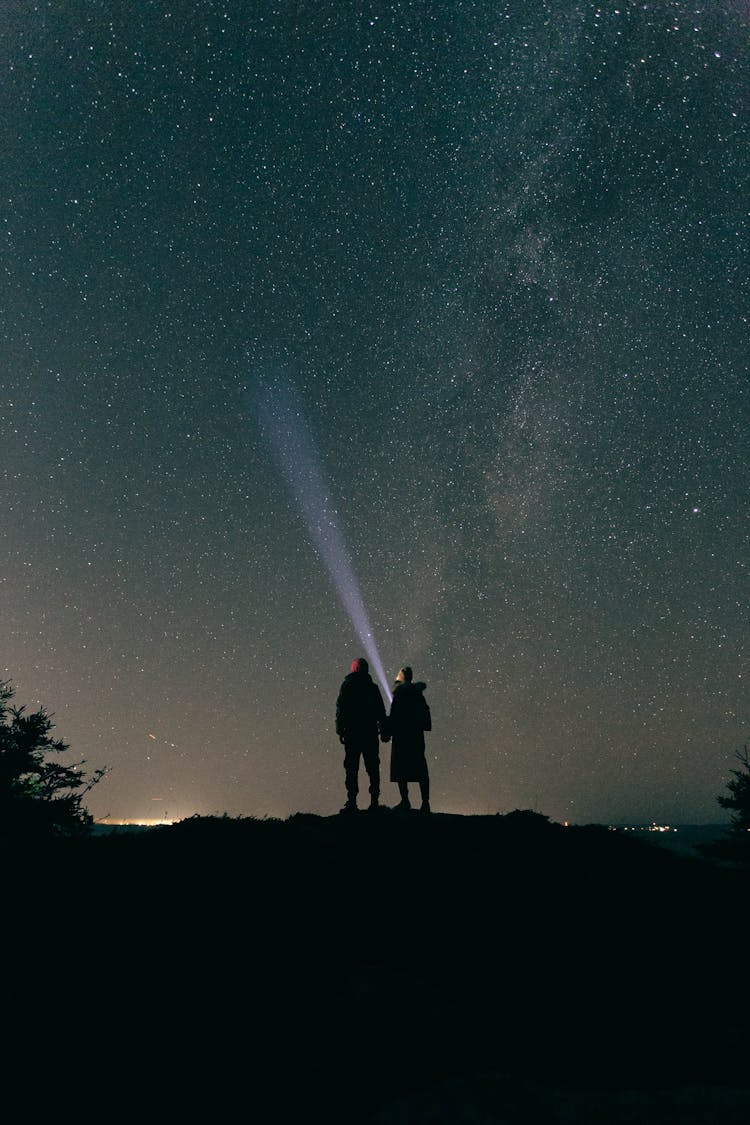 Couple Standing Under Starry Sky At Night