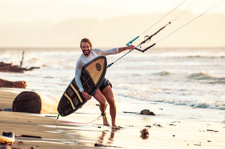 Man On Beach With Kite-Surfing Board