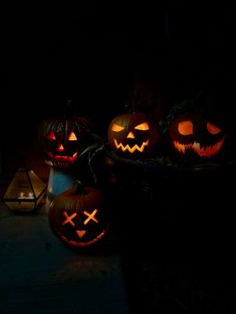 Four glowing carved pumpkins create a spooky Halloween decoration in a dark setting.