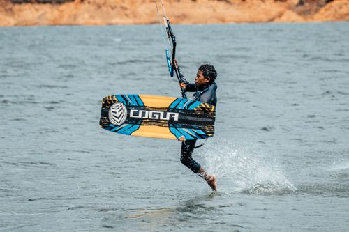 Free Energetic kitesurfing action captured with a sleek board against ocean waves. Stock Photo