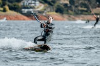 A Woman in Black Wetsuit Surfing on Sea