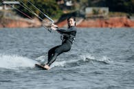 Man in Black Wetsuit Surfing on Water