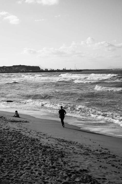 Grayscale Photo of People on Beach