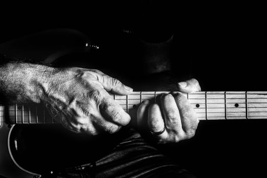 Detailed black and white image of hands playing an electric guitar.. detailed, black, white