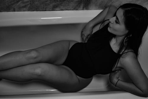 Grayscale Photo of Woman in the Bathtub