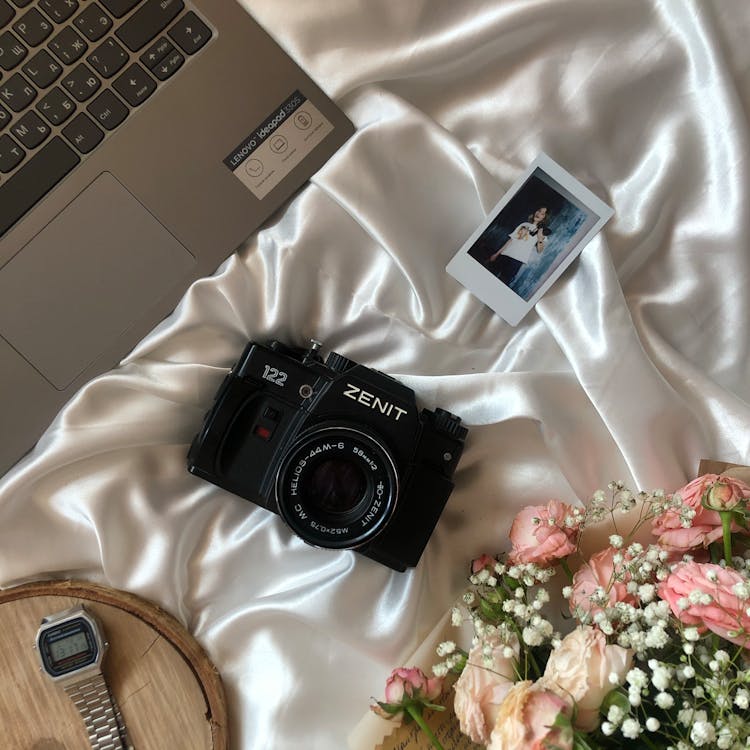 Camera And Photo On White Sheet