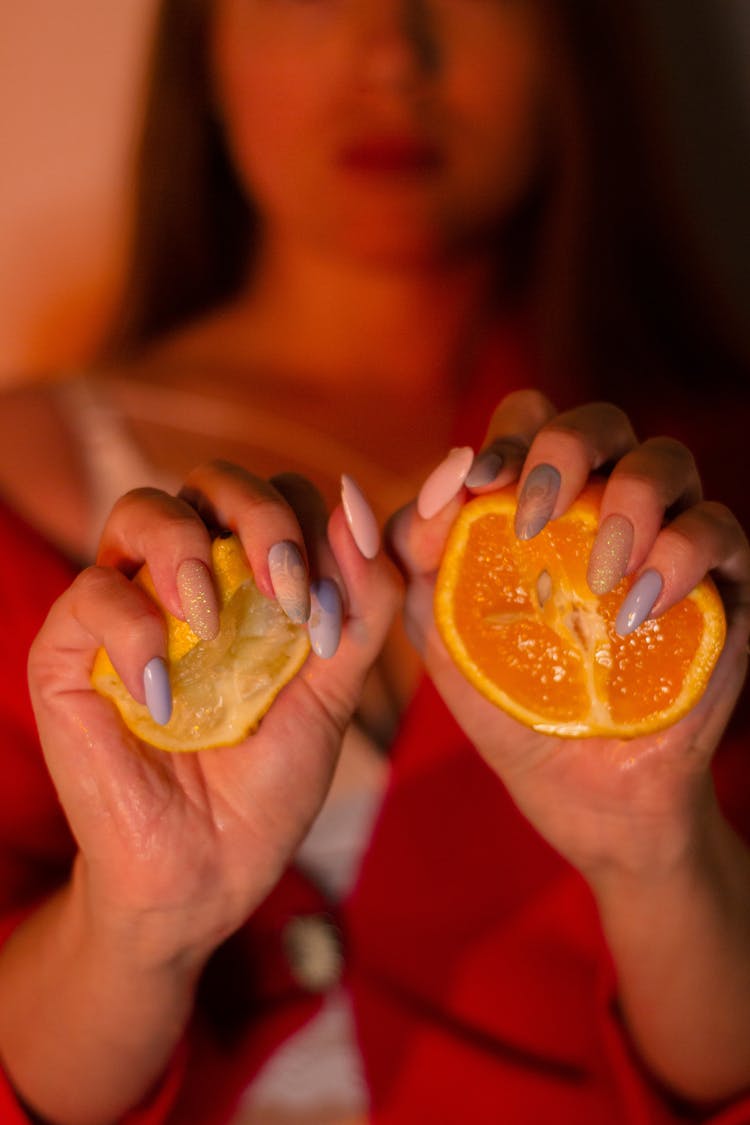 Woman Squeezing A Lemon And An Orange In Her Hands 