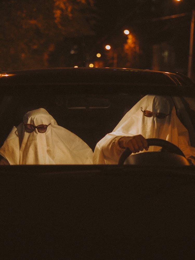 Two People In Ghosts Costumes In Car