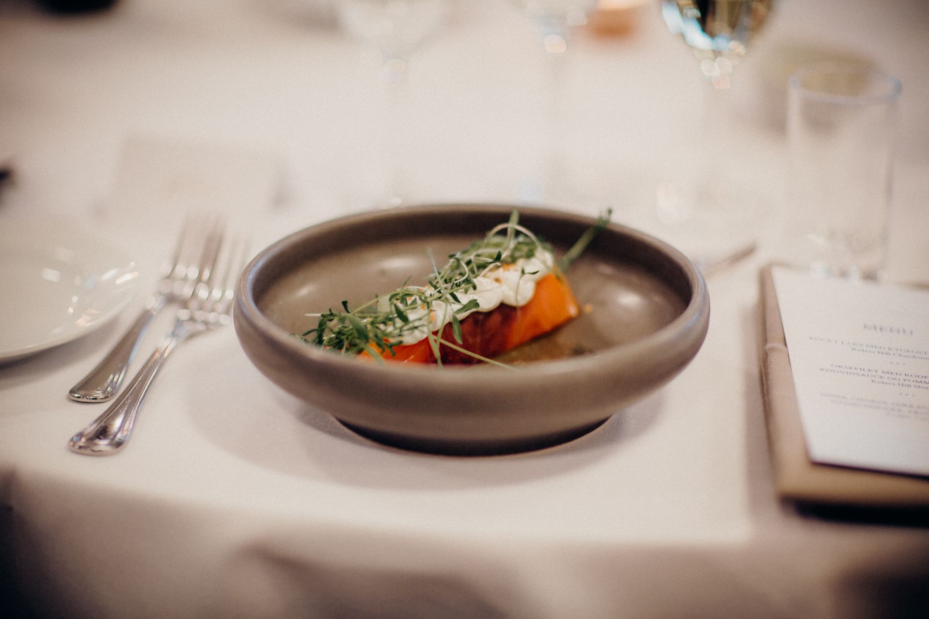 A gourmet meal artfully presented on a table set for fine dining, showcasing sophisticated plating.