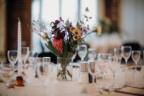 Free A beautifully set dining table featuring a stunning floral centerpiece in a vibrant setting. Stock Photo