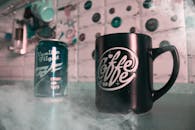 烟熏色的台面上摆放着复古风格的咖啡杯和苏打水罐，营造出复古氛围