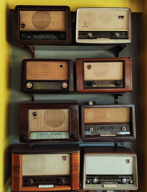 Free A collection of vintage radios displayed on a wall, showcasing retro aesthetics and design. Stock Photo