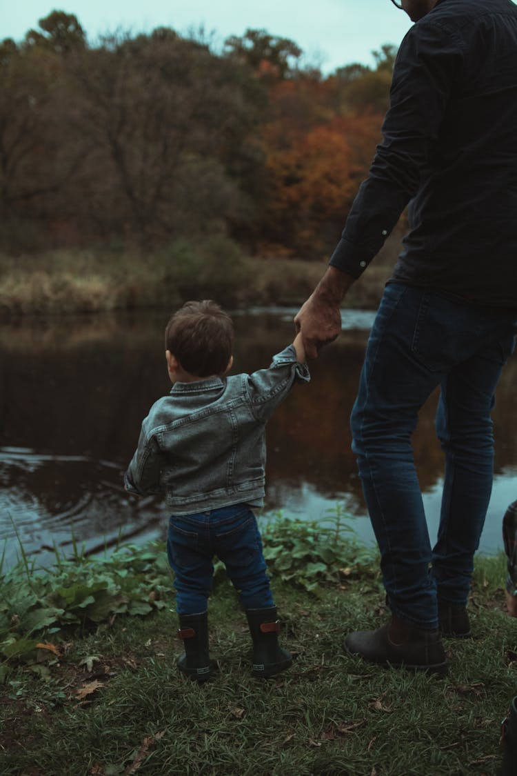 Father And Son Standing Near The River