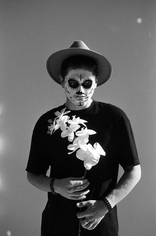 Man in Halloween Mask, Hat and with Flowers