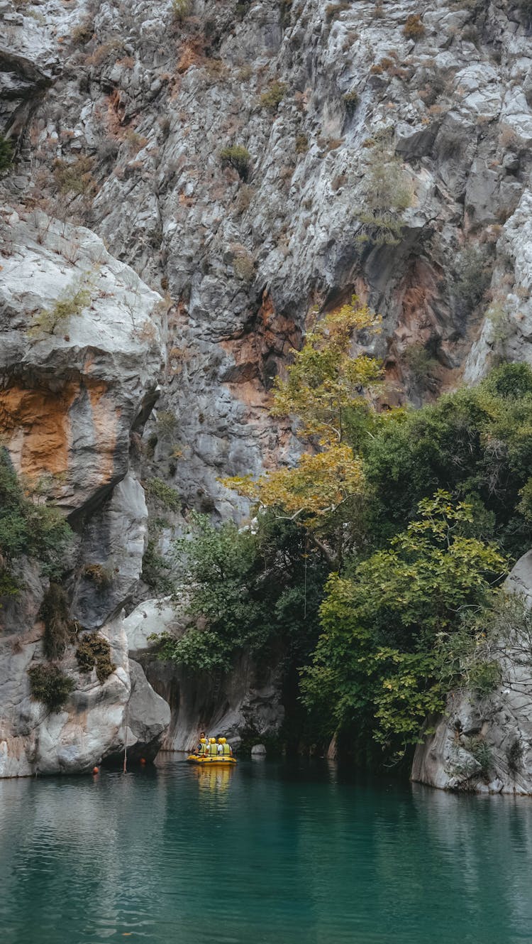 People On Pontoon Among Rock Formations