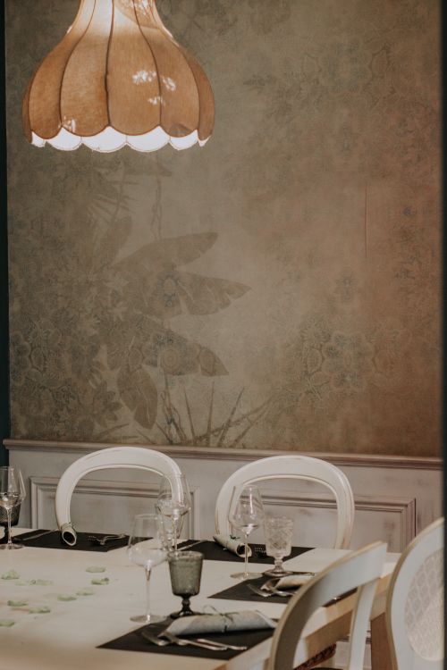Free Cozy dining setting with elegant table arrangement under a vintage chandelier. Stock Photo