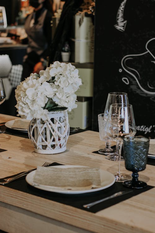 Základová fotografie zdarma na téma bílé květy, dřevěný stůl, prostřený stůl