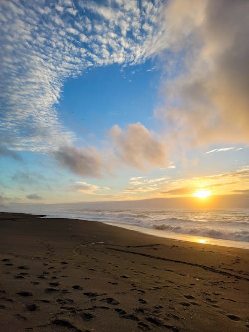 Free Sandy Beach at Sunrise and Clouds in Sky Stock Photo