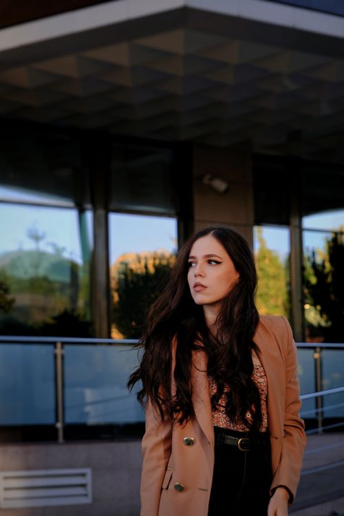 Free Elegant woman in fashion coat in urban area during twilight, exuding modern sophistication. Stock Photo