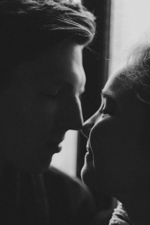 A Grayscale Photo of a Man and Woman Facing Each Other