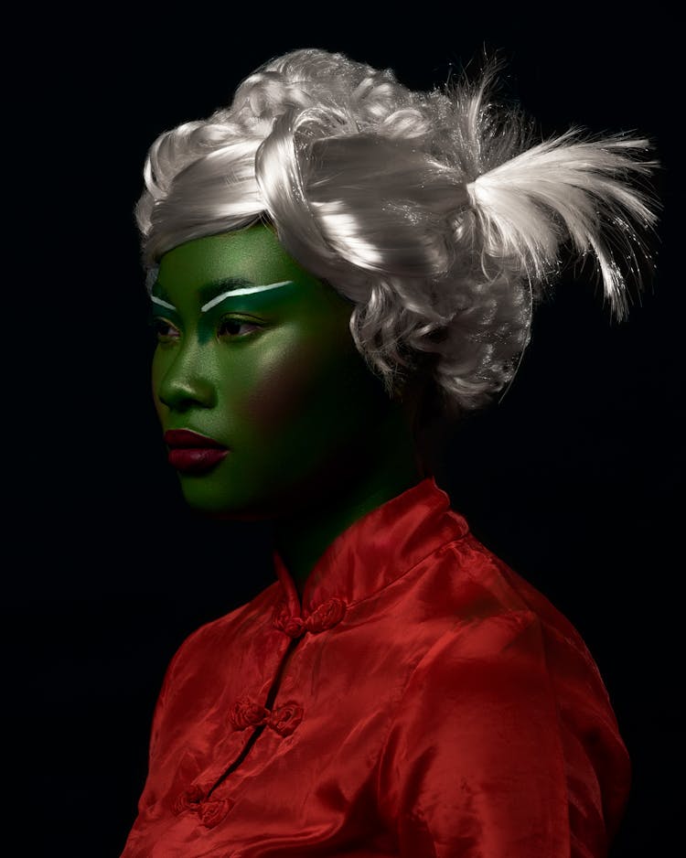 Woman With Face Painted On Green And Silver Hair