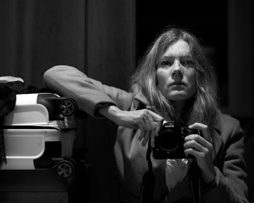 Grayscale Photo of Woman Holding a Camera