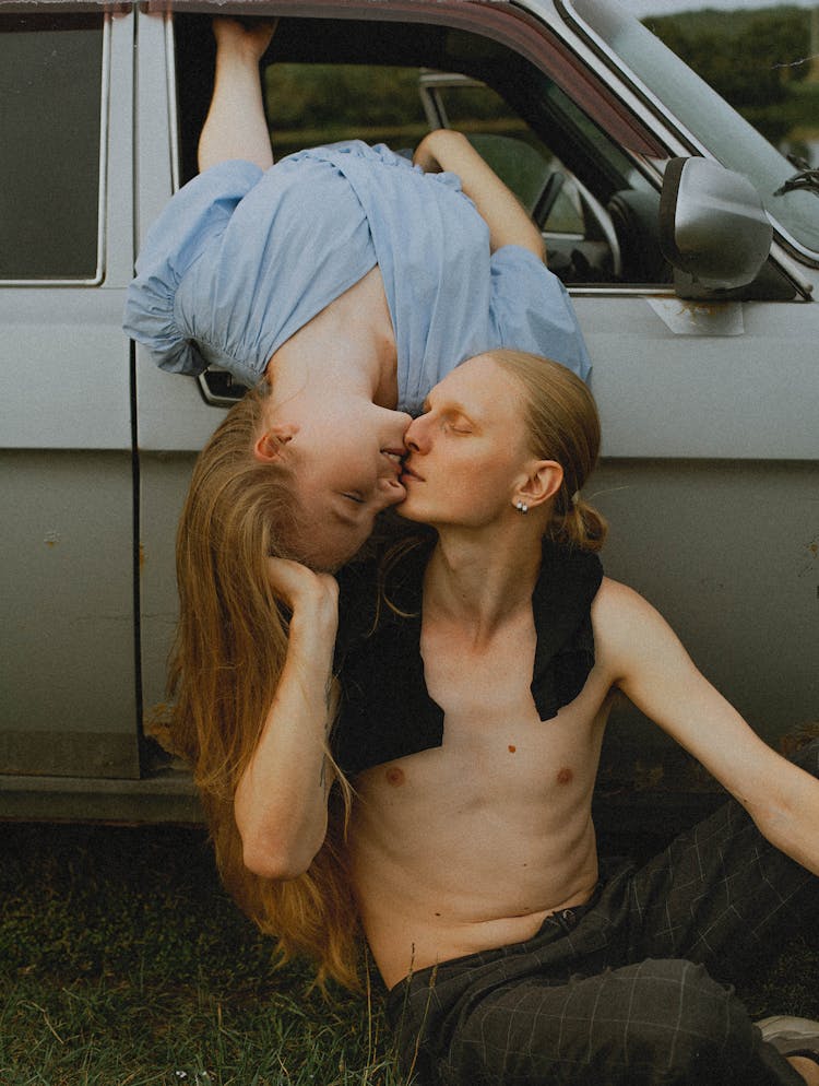 Man Kissing Woman Leaning From Car