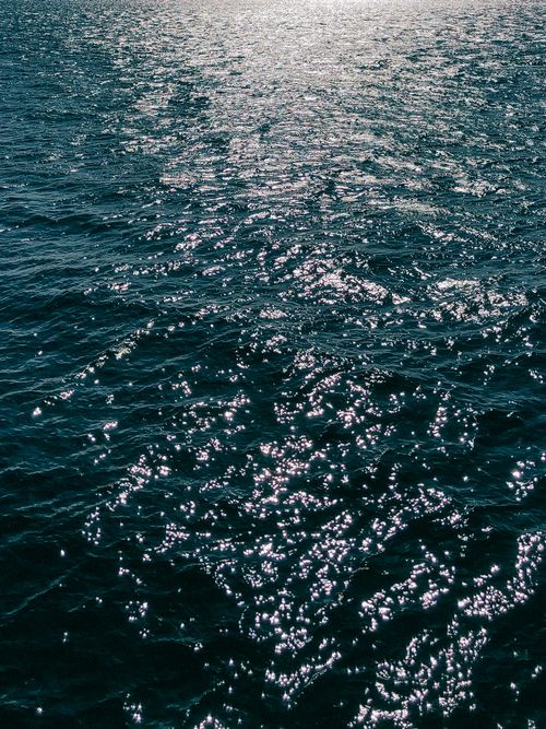Free Serene image of sunlit rippling water, capturing the shimmering and dynamic movement. Stock Photo