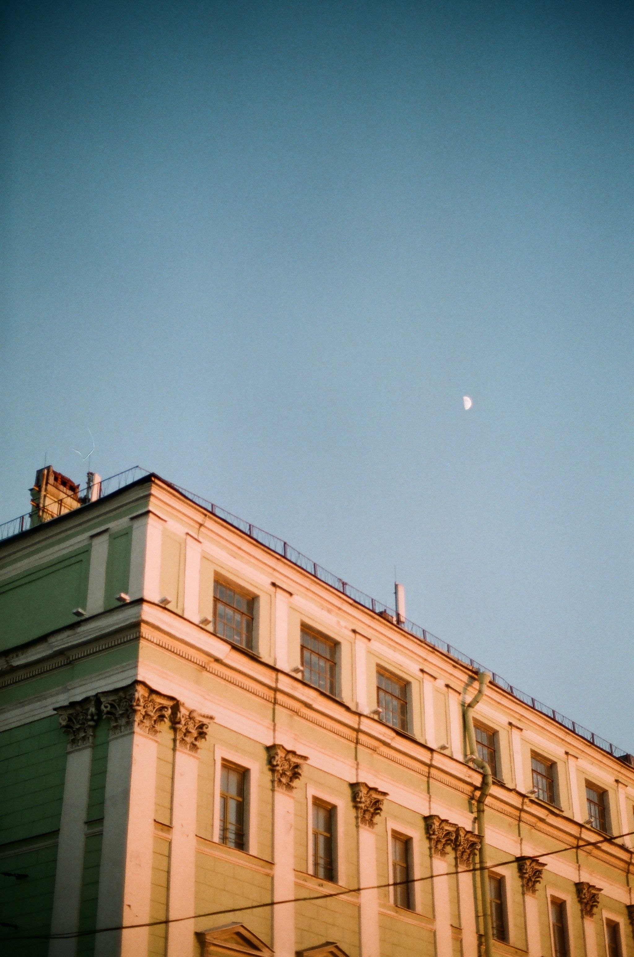 Old building facade under blue sky with moon · Free Stock Photo