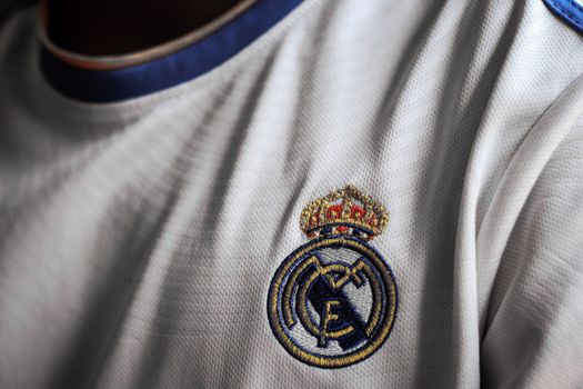 Detailed close-up of a soccer jersey featuring a prominent emblem on white fabric.