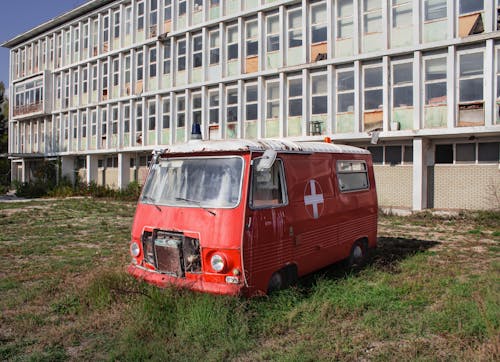 A Red and White Ambulance Junked Near  Building