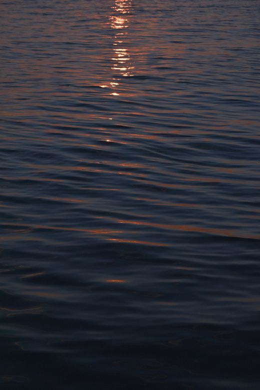 Sunset reflections rippling across calm water — gökçe erem on Pexels