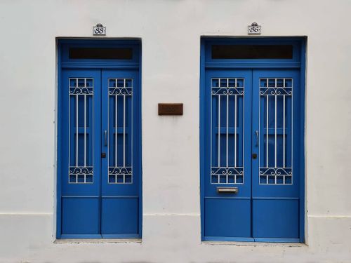 Free Blue doors with decorative grills on a white facade in Malta, showcasing Mediterranean architecture. Stock Photo