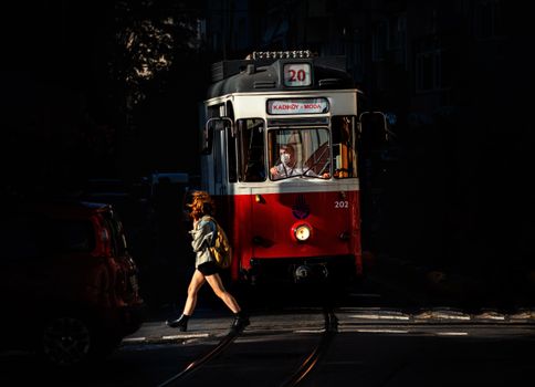 A Woman Crossing on the Street Near the Tram