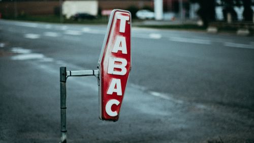Free A vintage 'Tabac' sign on a street with blurred background, captured at dusk. Stock Photo