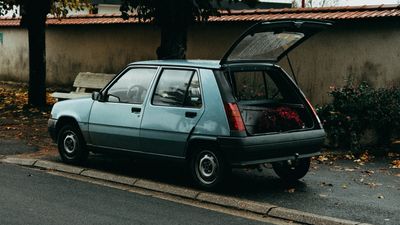 Sea-green compact hatchback with its tailgate open, photo by Mathias Reding on Pexels