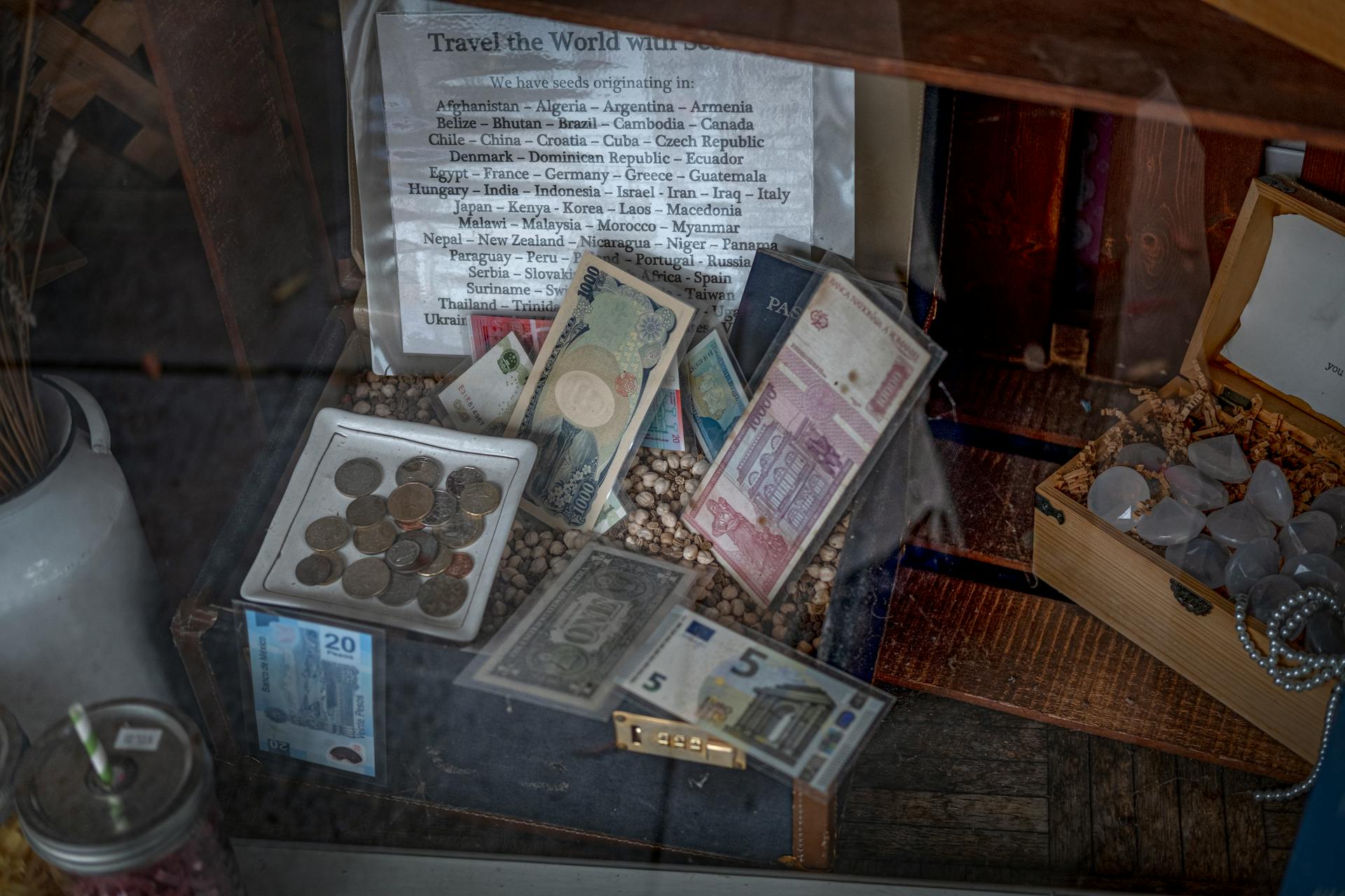 A diverse collection of global coins and banknotes displayed in a vintage setting.