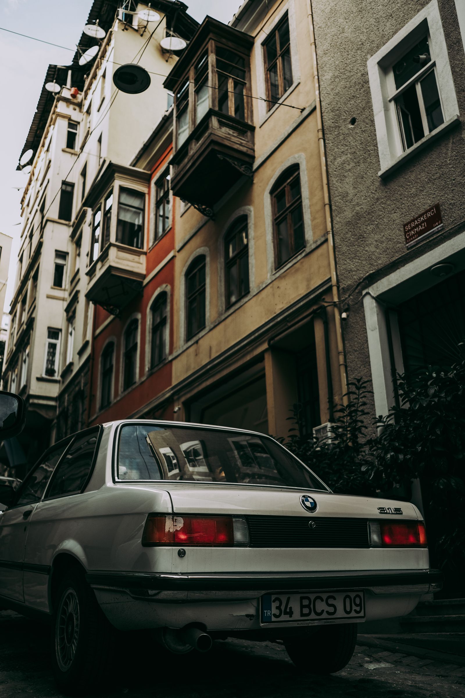 White automobile parked on a narrow city street
