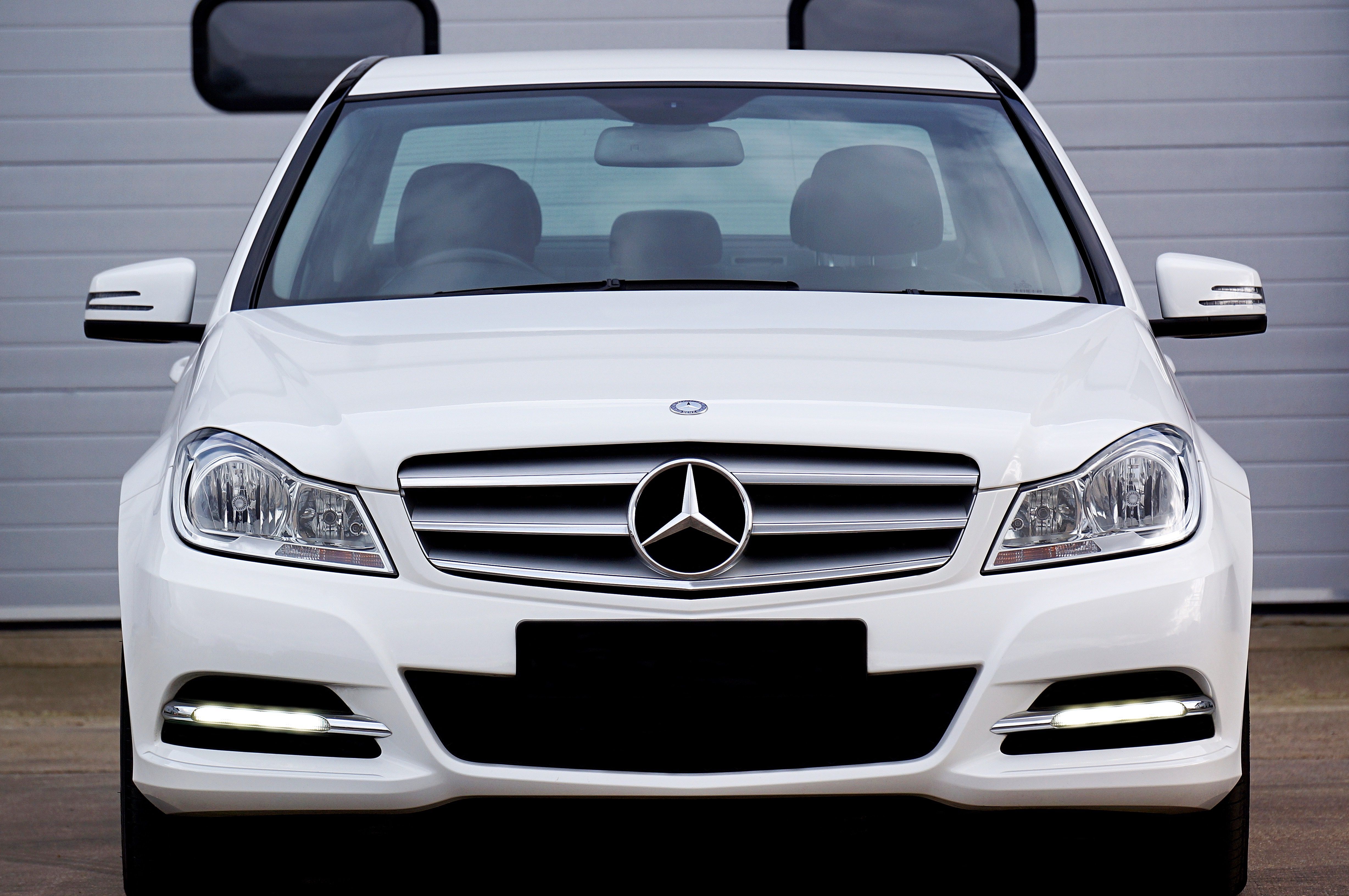White Mercedes Benz Car Near Grey Building Free Stock Photo