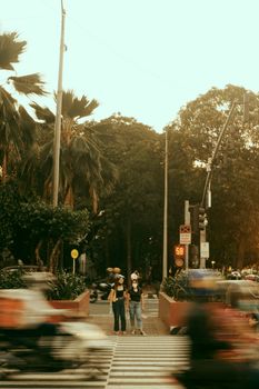 Dynamic city scene with motion blur at a crosswalk, highlighting urban life and movement.