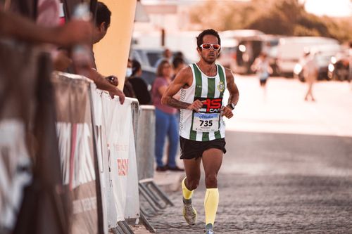 Free Athlete in sportswear running a marathon on a sunny day with spectators. Stock Photo
