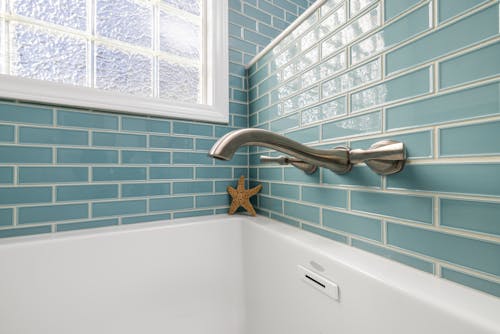 White Bathtub With Blue and White Wall Tiles